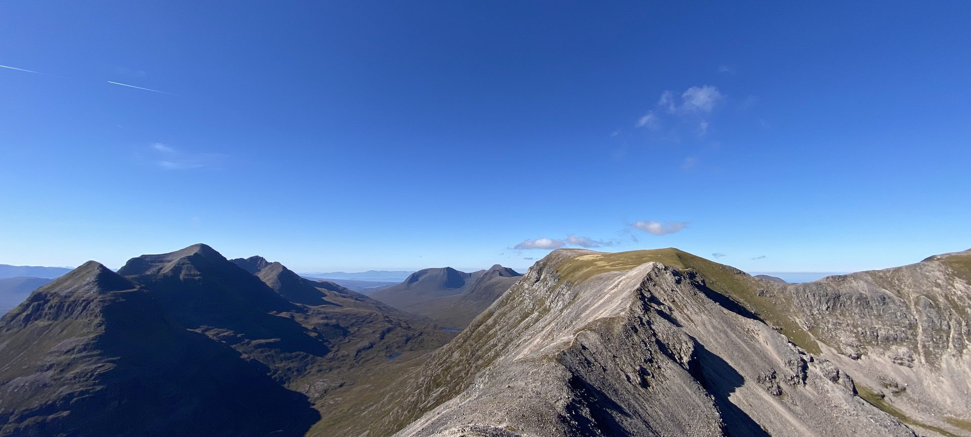 Rocky mountain ridge beneath a wide blue sky in the Scottish Highlands